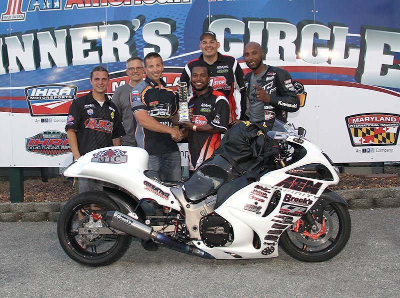 A young Richard Gadson holding the trophy in the winner's circle at Maryland International Raceway, his white Hayabusa up front