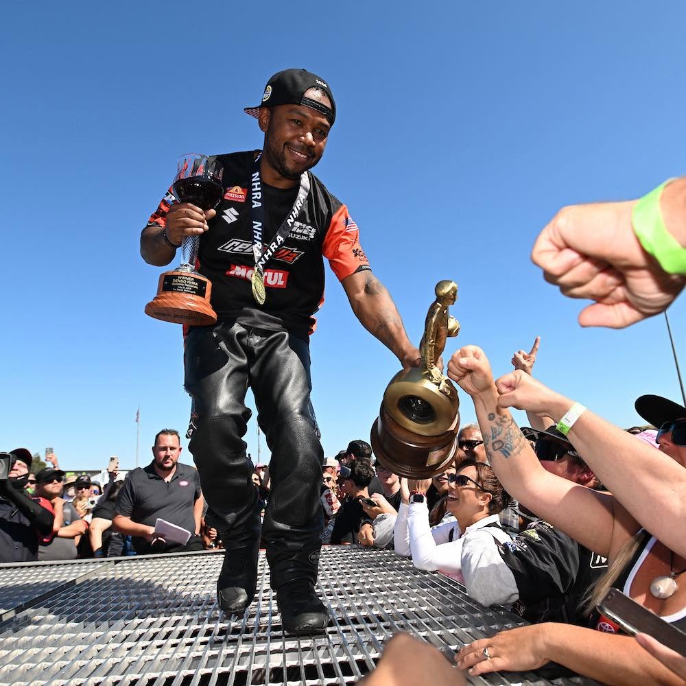 Gadson handing the Wally trophy into the crowd from the winner's circle